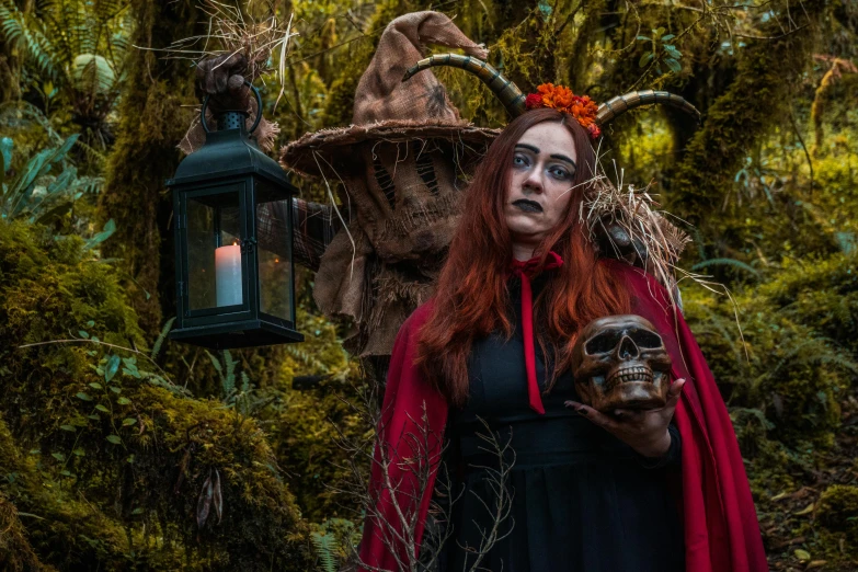 a woman with horns, red hair and red hair is posing with a skeleton