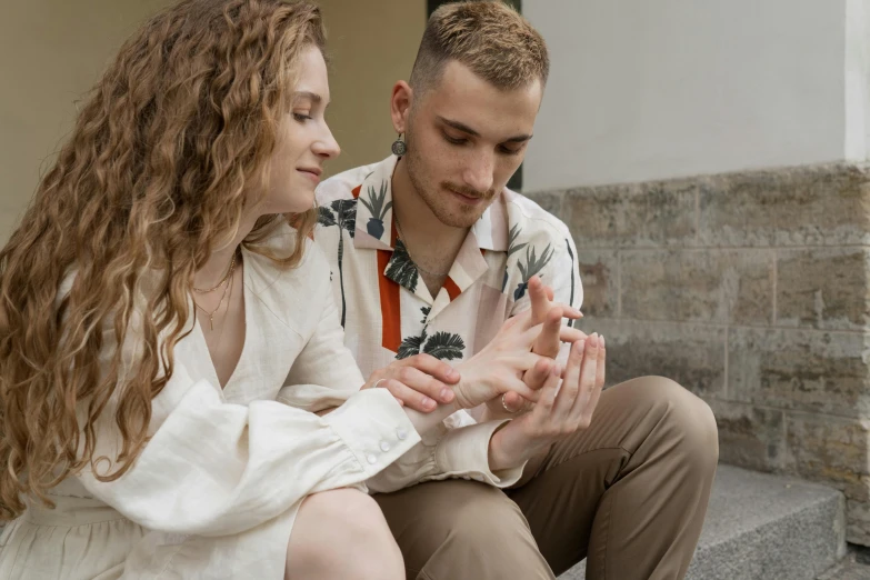 a young man sitting next to a woman on the stairs