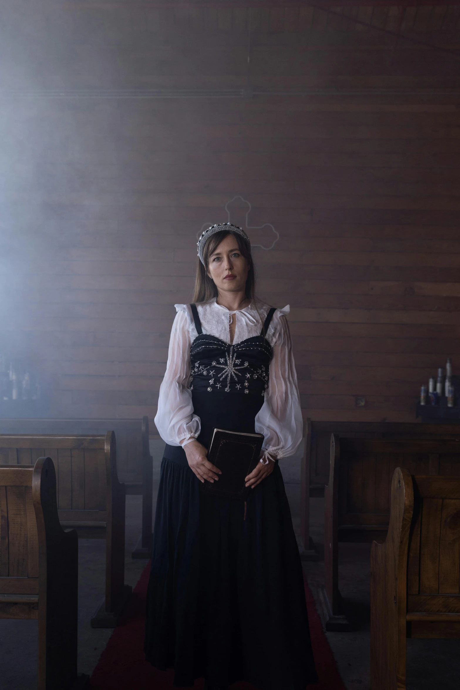 a girl dressed in a gothic look is standing near a wooden wall