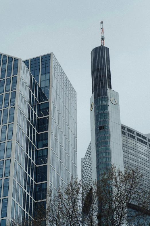 the three modern buildings in a city with a clock on top