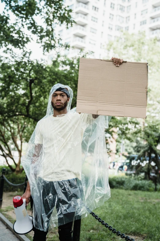 man in plastic wrapped around and holding up a sign