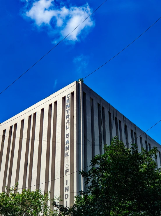 an office building with a tree and power line in the background