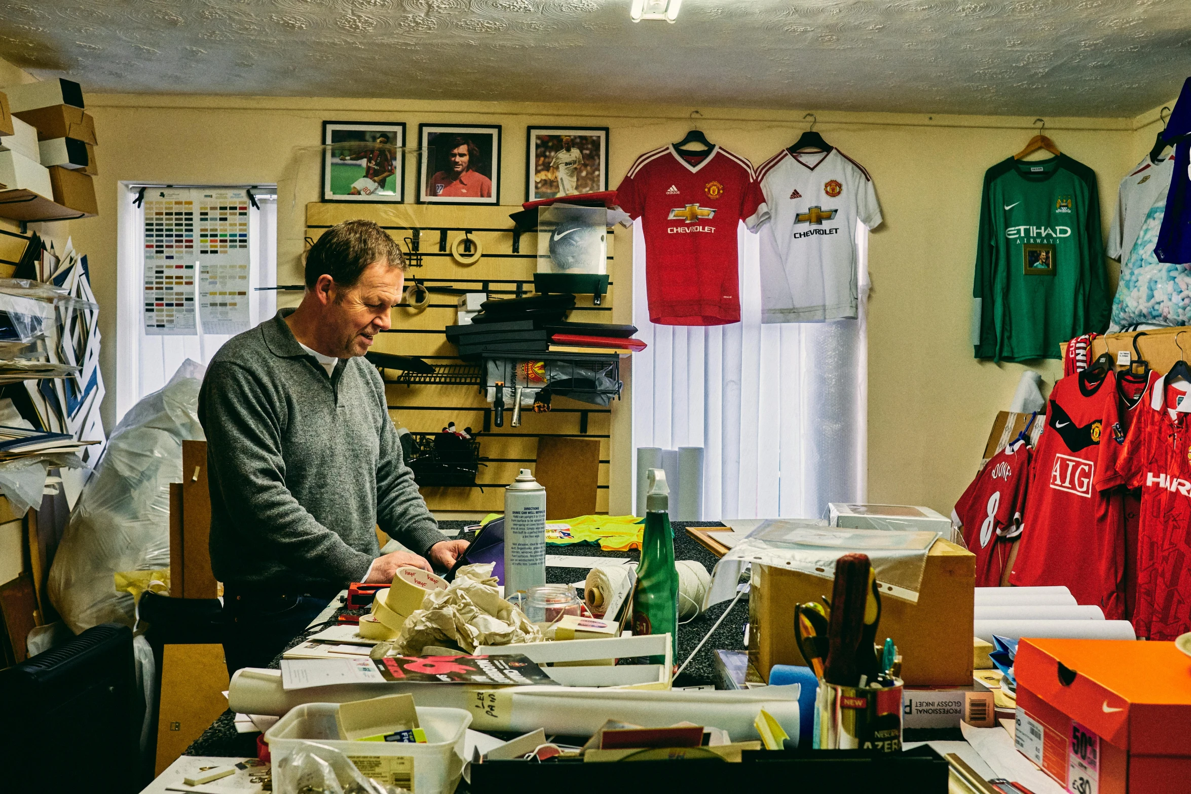 the man at his work space looks at a bunch of objects