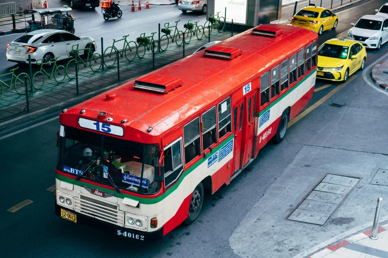 bus with many passengers on street next to bridge