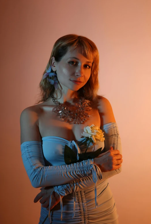 a pretty young lady in a white dress holding a flower