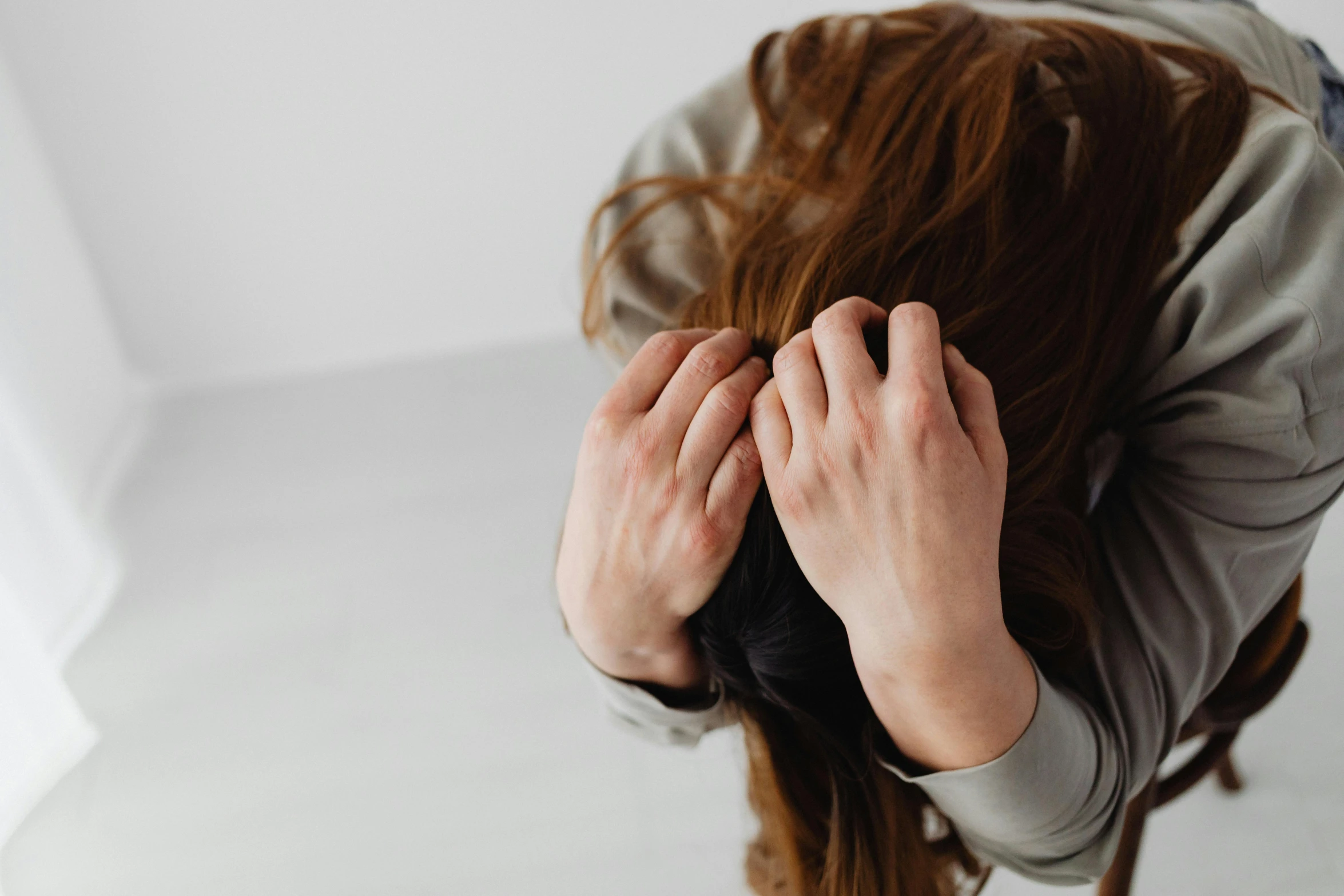 a person standing with their hands on her head