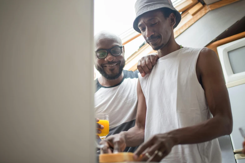 two men are making orange juice on a  board