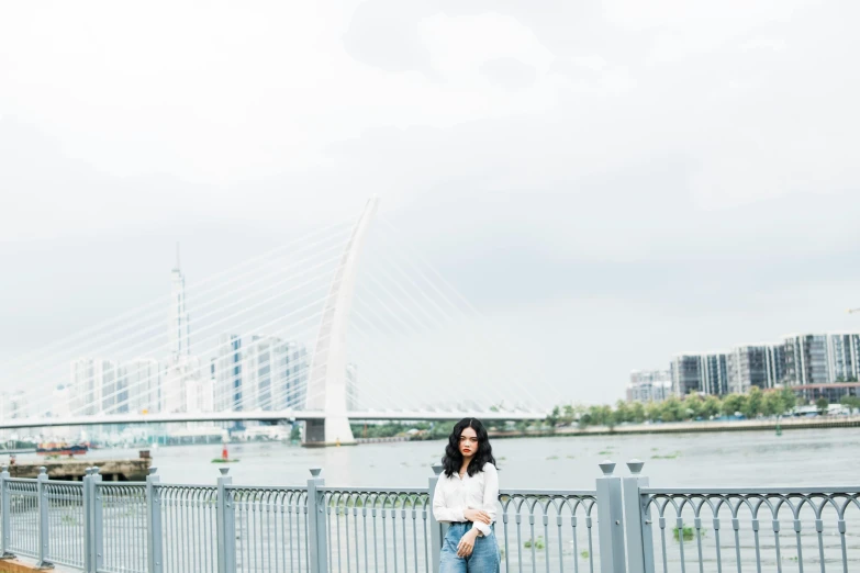 woman standing next to fence near body of water