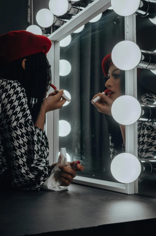 the woman in the black and white dress is applying her teeth