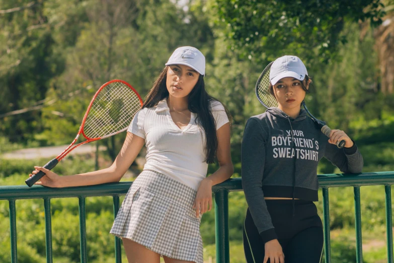 two women standing together with tennis rackets