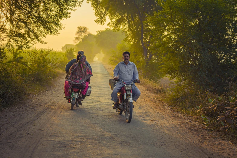 two people riding bicycles and bicycles on the side of a road