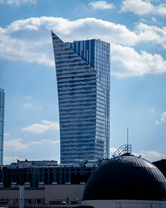 a very tall skyscr is seen from across the water