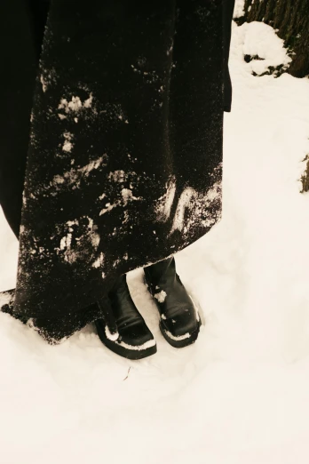 two people with slippers standing in the snow