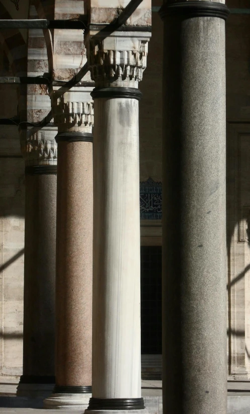 four white and grey pillars are in front of a building