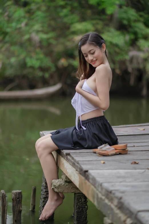 girl sitting on wooden dock posing for camera