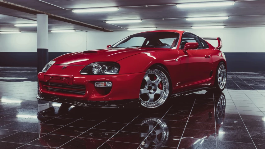 a red sports car in a building with large black and white tiled floor