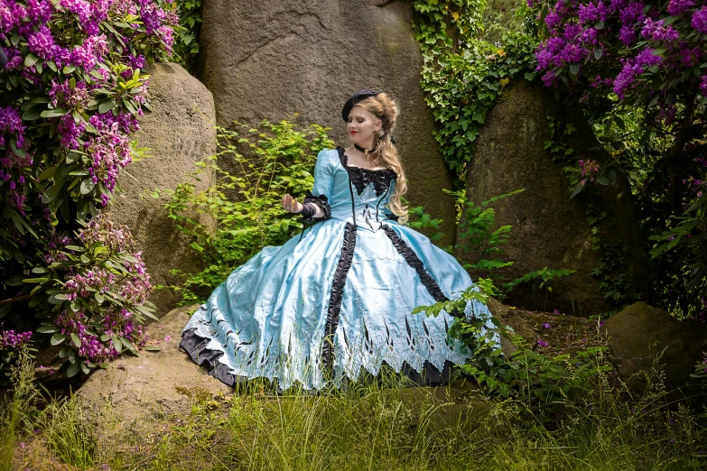 a woman in a gown posing next to flowers