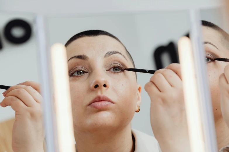 a woman that is in front of a mirror doing makeup