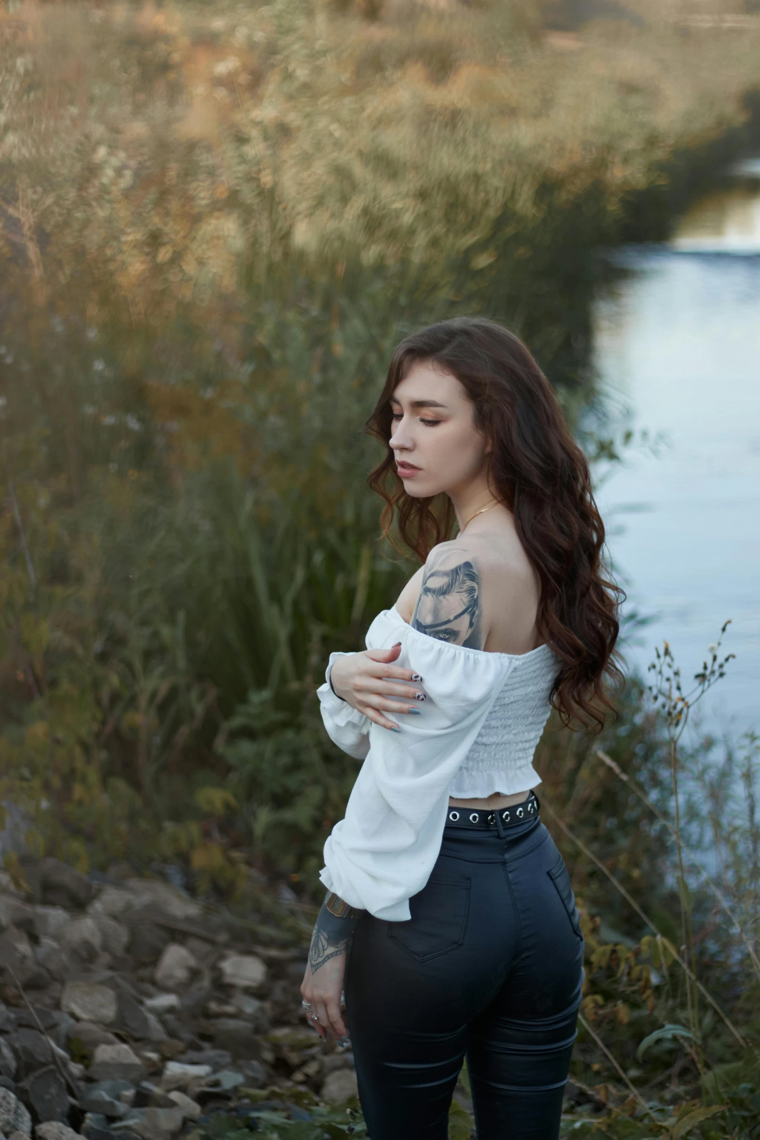 a woman standing next to a body of water