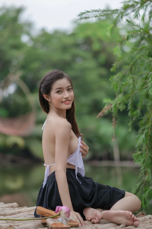 a girl poses next to a pond for a po