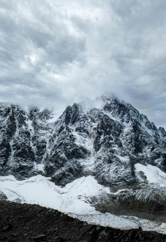 a snowy mountain is shown with clouds overhead