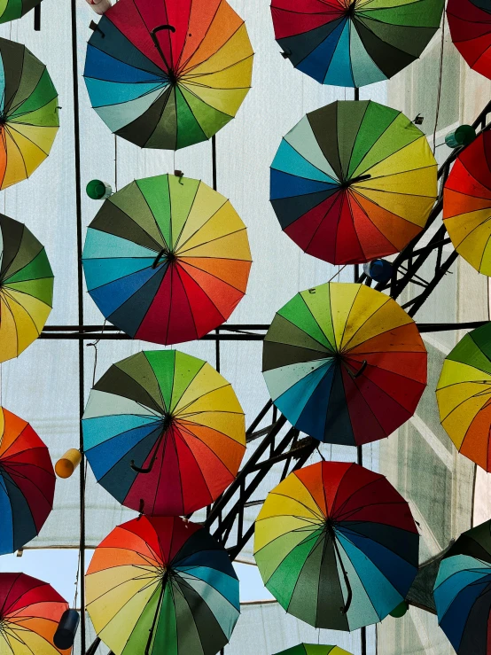 a group of colorful umbrellas on the sides of two building