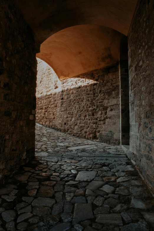 an empty alleyway with small stones between two buildings