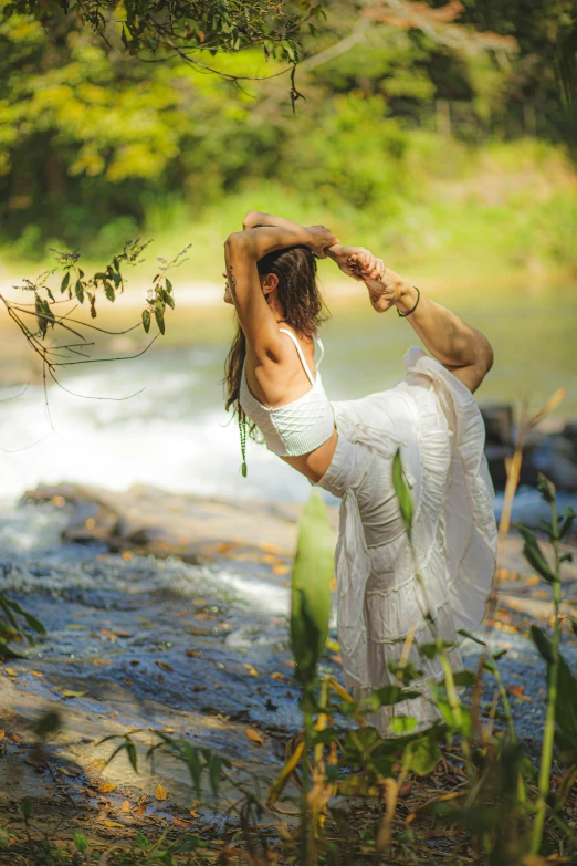 woman in white flowing river dress doing yoga