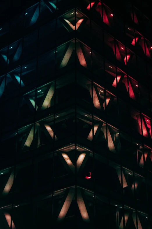 red light is shining in the glass exterior of a tall building