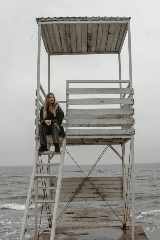 a person sitting on top of a metal ladder