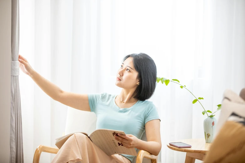 a woman sitting on top of a chair holding an object