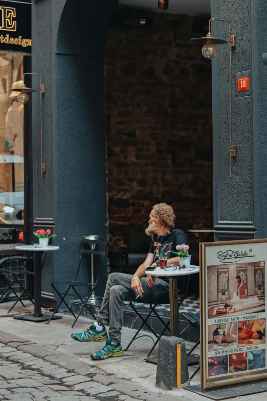 the young man sits at the table on his phone