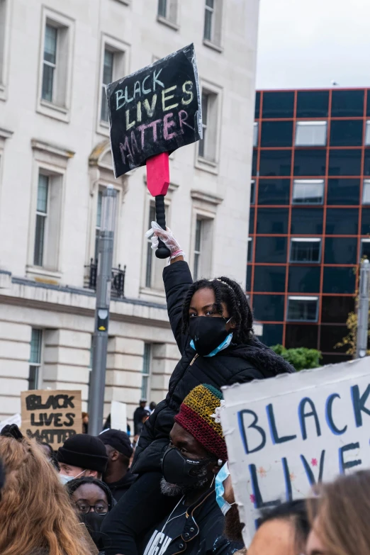 a woman holding a protest sign in the air