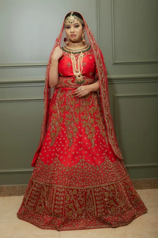 woman in red and gold wedding gown standing with arms crossed