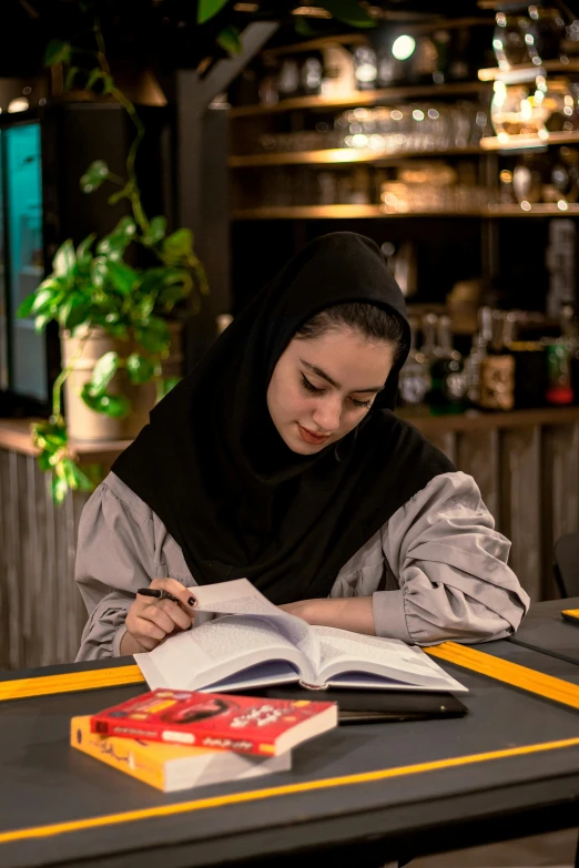 the woman is studying and writing at the table