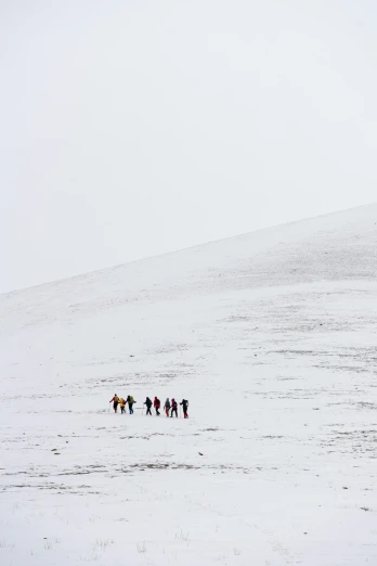 a group of people walk across snow covered ground