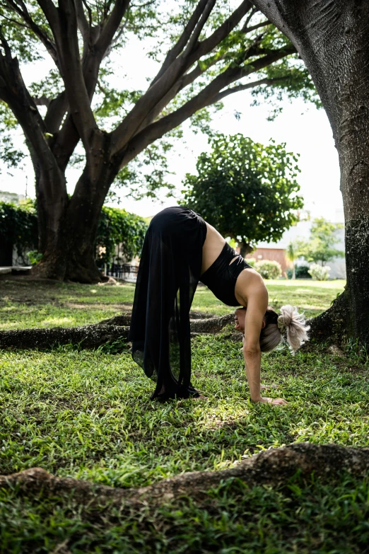 a woman in a black top doing yoga on her feet