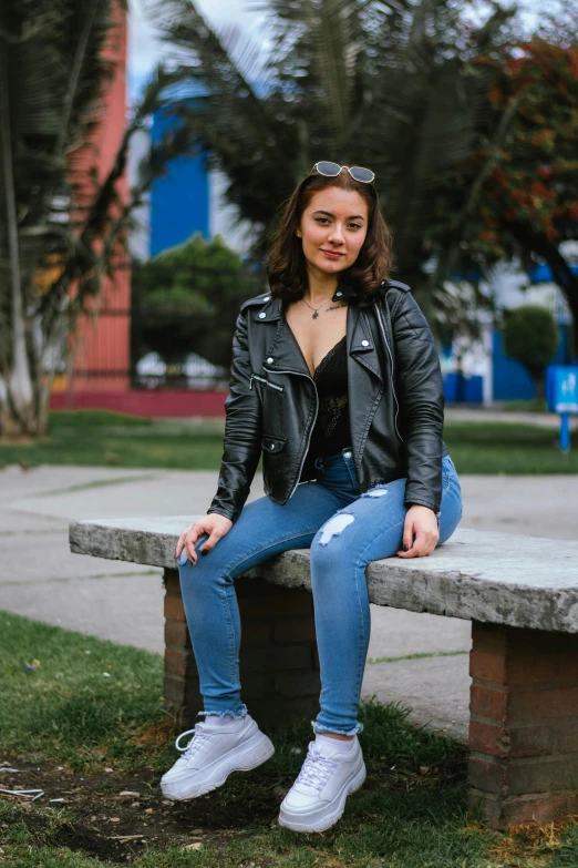 a woman sitting on top of a concrete bench