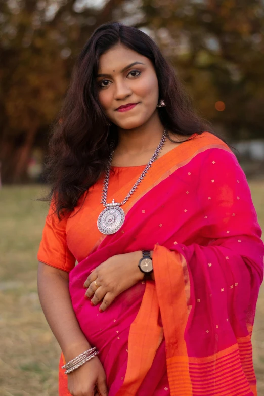 a young indian woman in an orange and pink sari