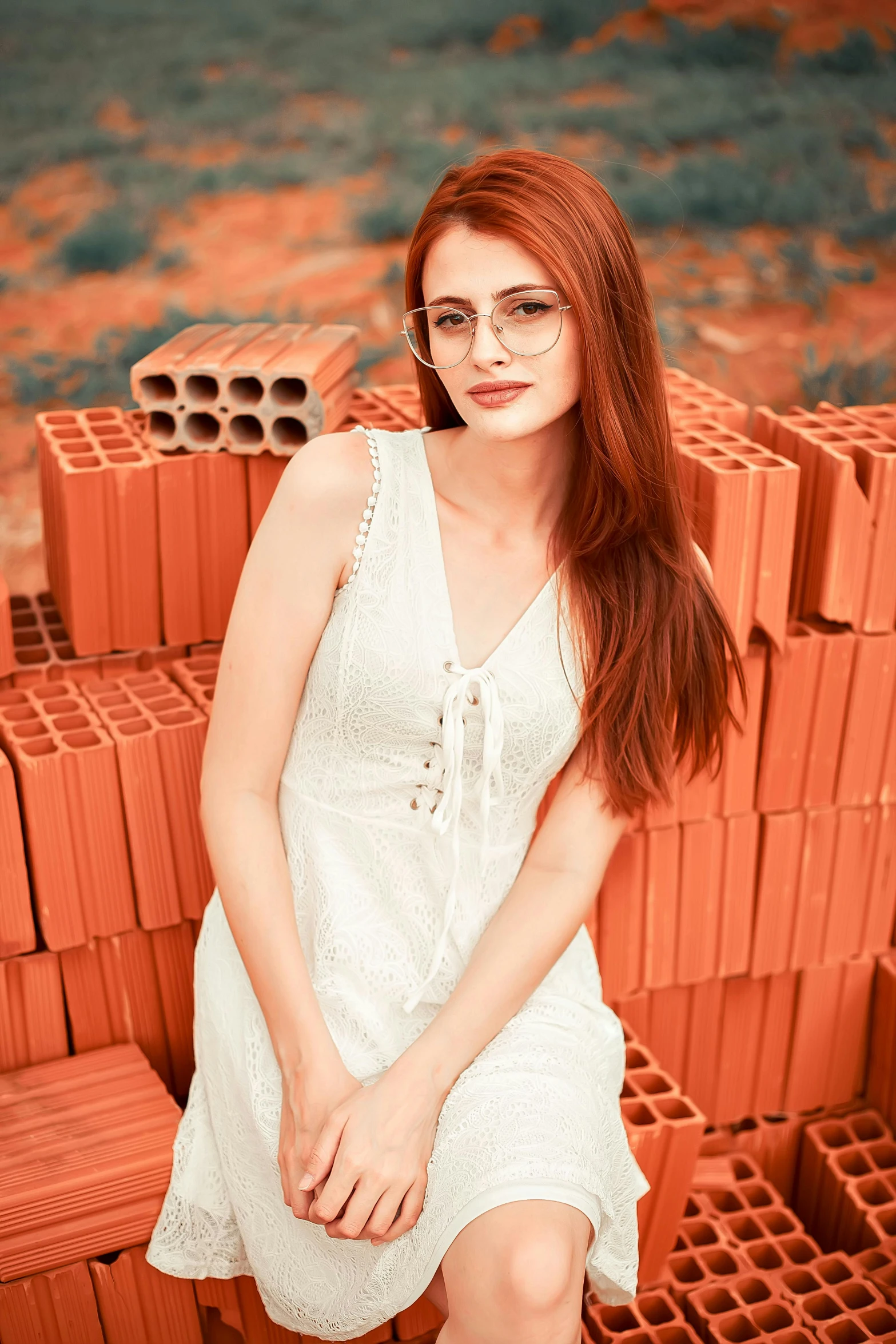 the young woman is sitting on bricks in front of her