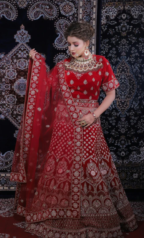 the woman is wearing a red indian bridal gown