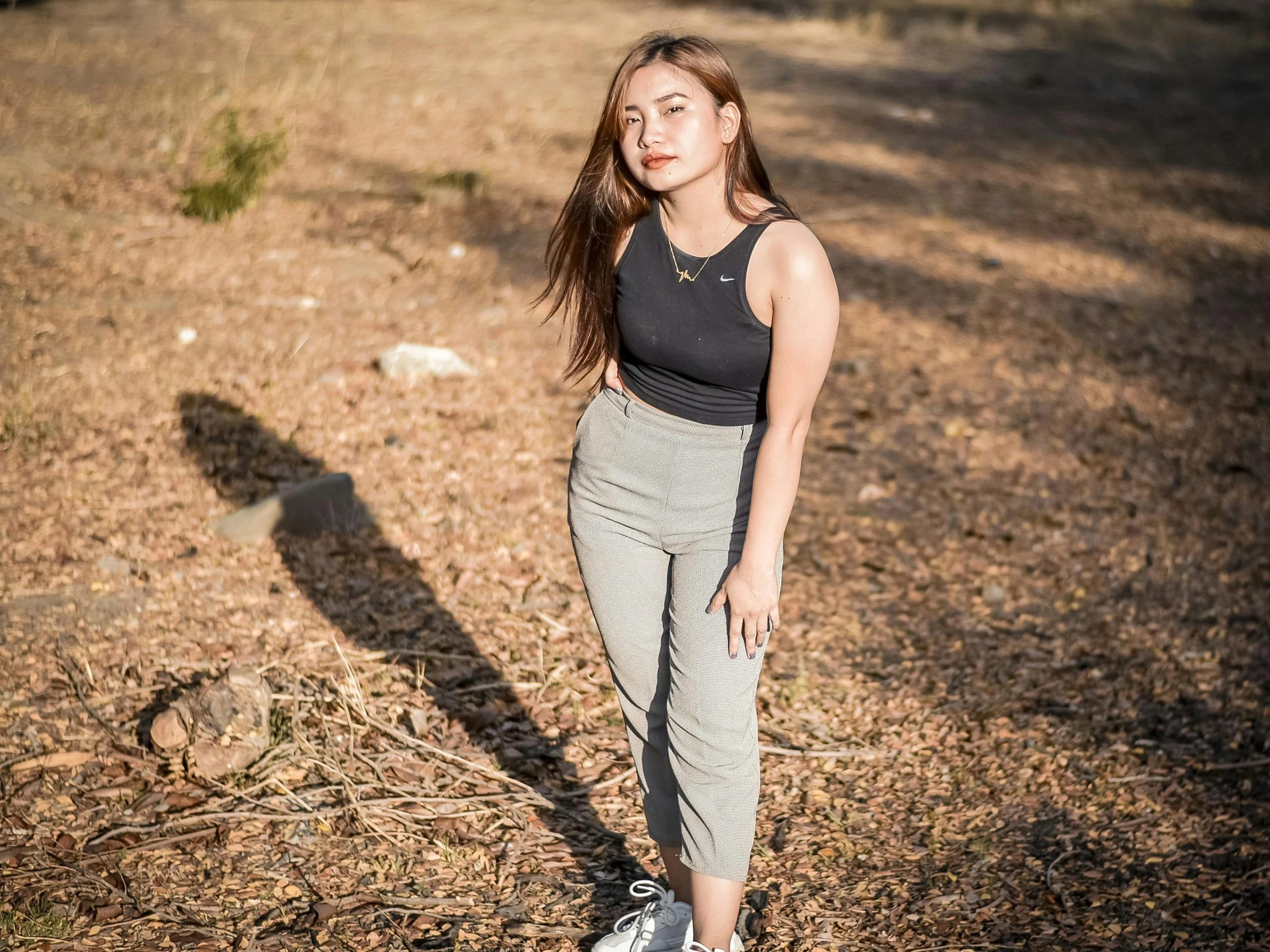 woman standing in front of a tree with her hands on hips