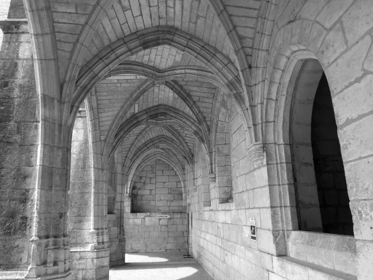 a long and arched corridor in black and white