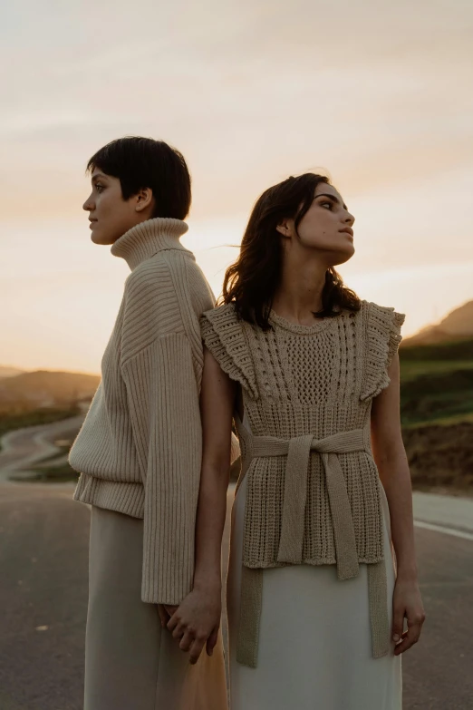 two women standing next to each other looking into the sky