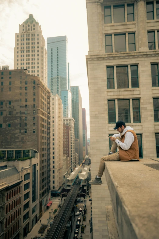 a man sits on a ledge in a city