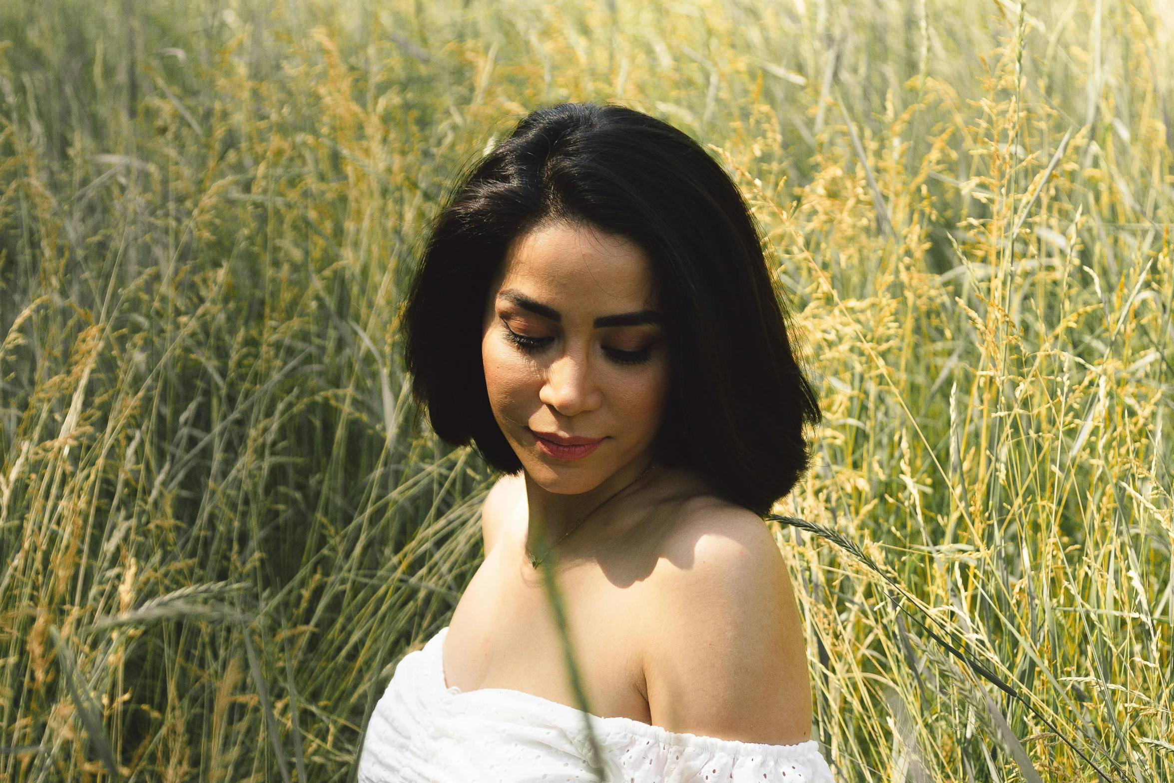 a woman in the middle of a field of tall grass