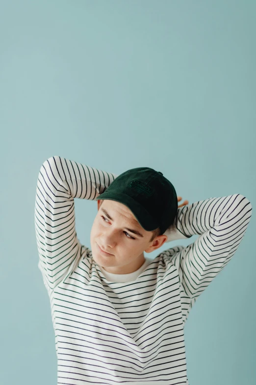 a boy with a striped sweater, turban and cap on