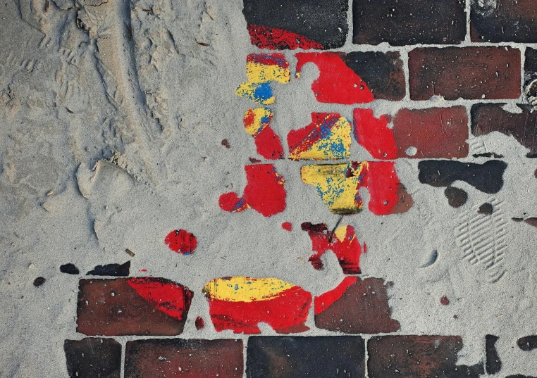 a brick wall with red and yellow paint on it