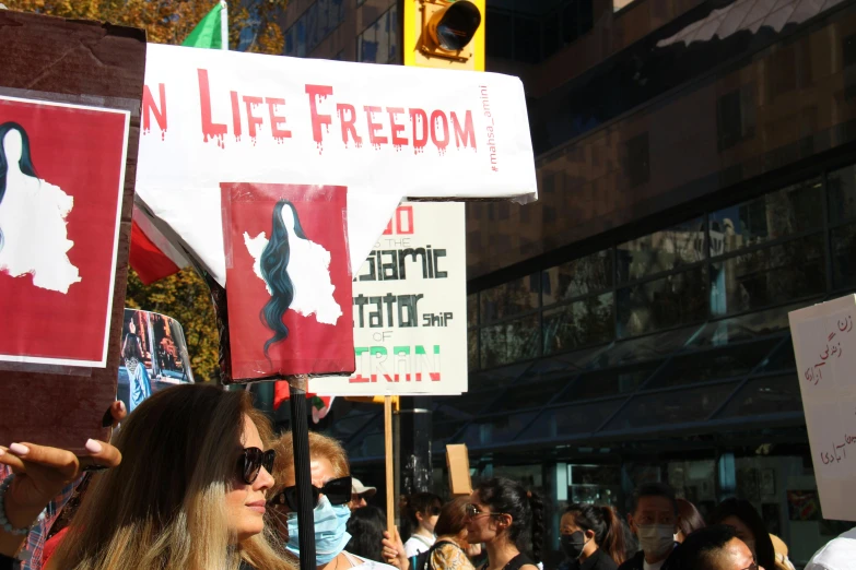 many people holding signs with different images of women and one man