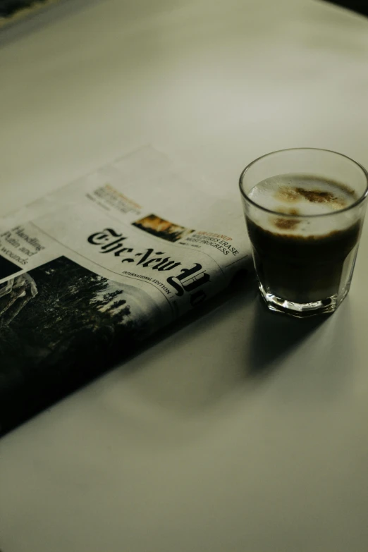 a cup of liquid and a newspaper are shown